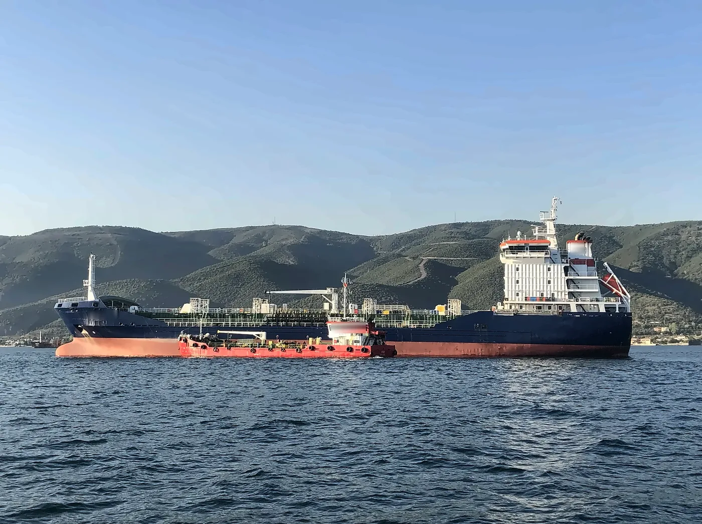 A bunker barge alongside a tanker at anchor
